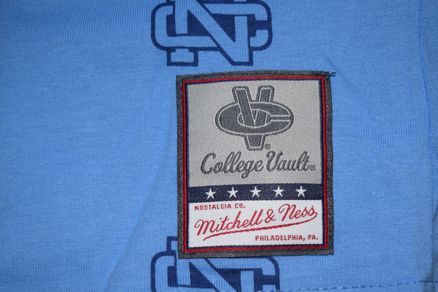 Mitchell & Ness label on a blue garment with NC logo